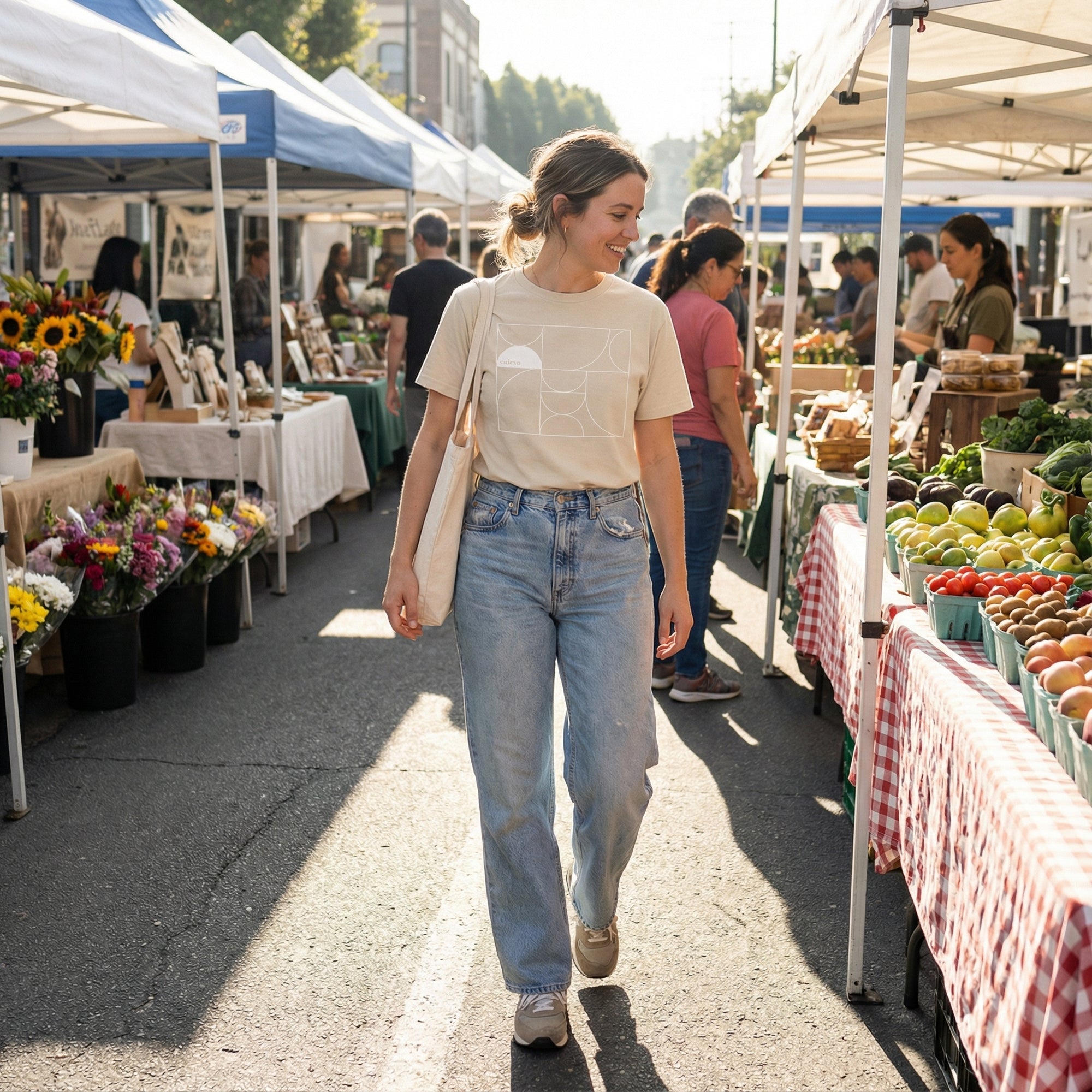 Woman walking through an outdoor farmers market with tents and tables displaying various goods.